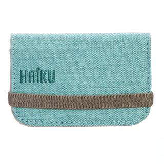 Teal cardholder with brown strap and 'Haiku' branding on a white background