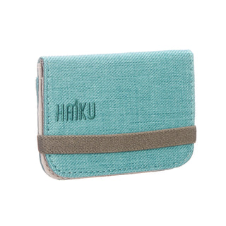 Teal cardholder with brown accent and 'HAIKU' branding on a white background
